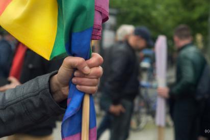 Eine Faust hält eine Regenbogenfahne
